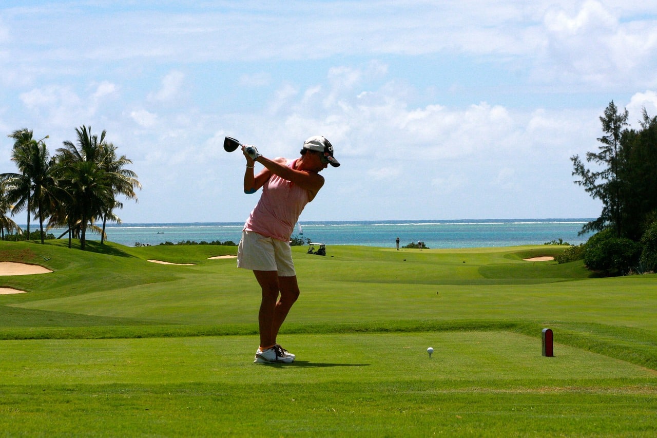 femme jouant au golf au bord de la mer
