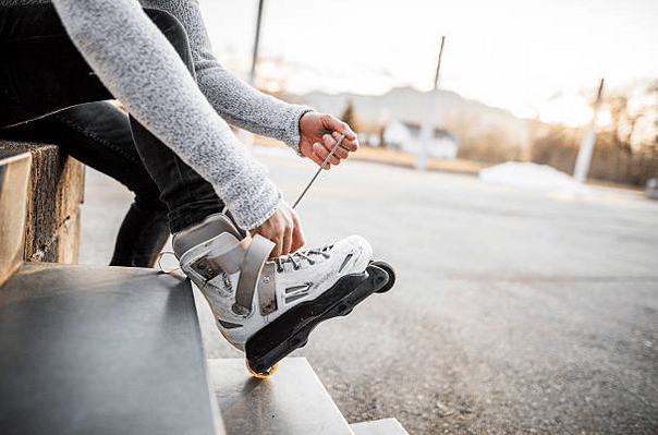 Gros plan sur les rollers d'une fille qui en lace les lacets