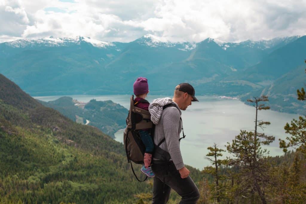 Père qui marche avec son enfant sur le dos